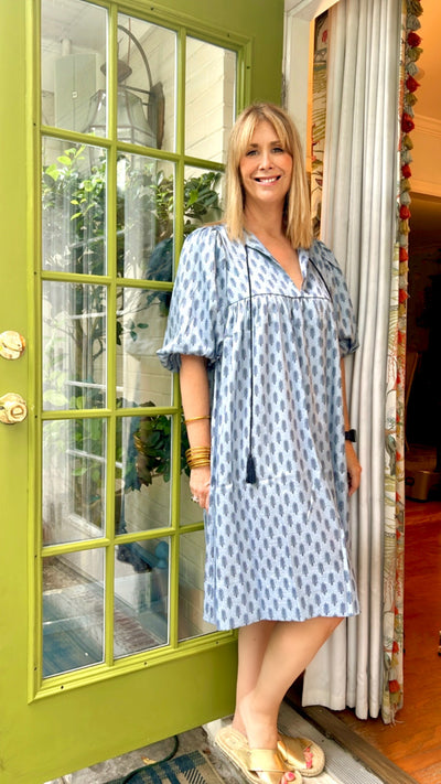 Side View.  Blue & navy feather print loose fitting midi dress.  Bubble sleeves & tassel ties give this boho style a classic vibe!